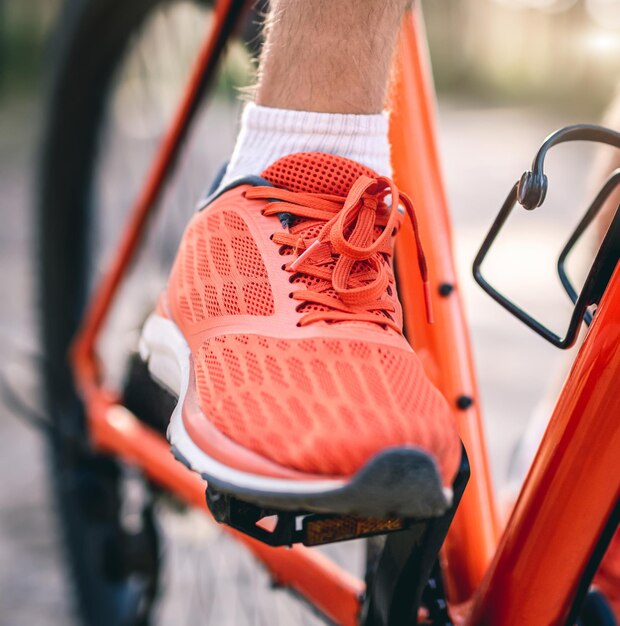 Bein im Sneaker auf Fahrradpedal