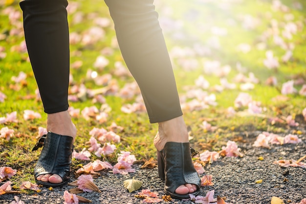 Beinansicht einer Frau, die mit Blumen geht. Asiatische Frauenbeine