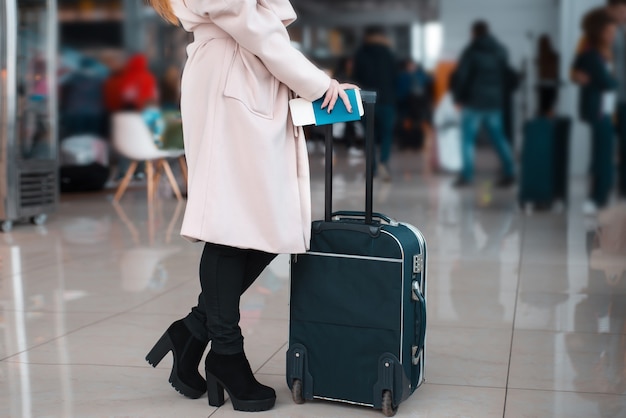 Beine der Geschäftsfrau mit Gepäck im Flughafen.