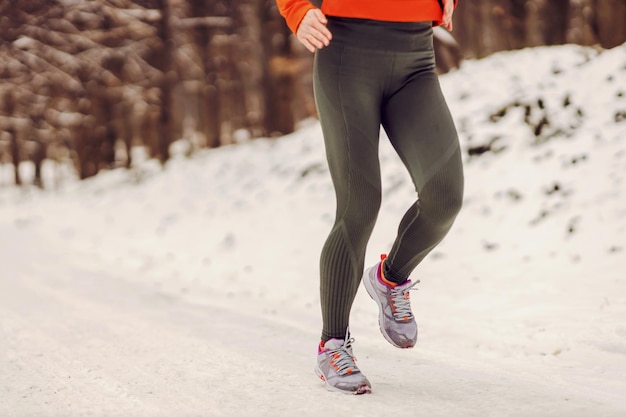Beine, die am Tag in der Natur auf Schnee laufen Beine Winter Fitness Sport Natur gesunde Gewohnheiten