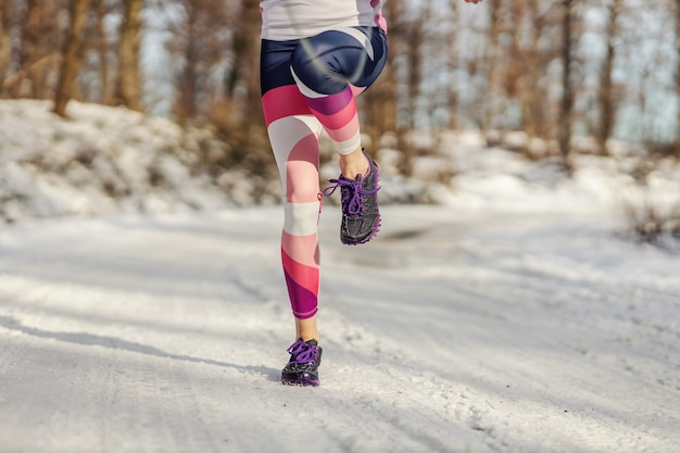 Beine, die am verschneiten Wintertag ein Seil in der Natur überspringen. Cardio-Übungen, gesunder Lebensstil, Winterfitness