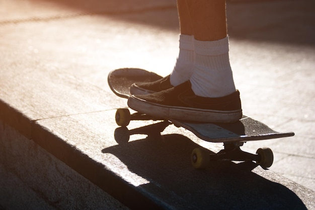 Beine, die ein Skateboard fahren.