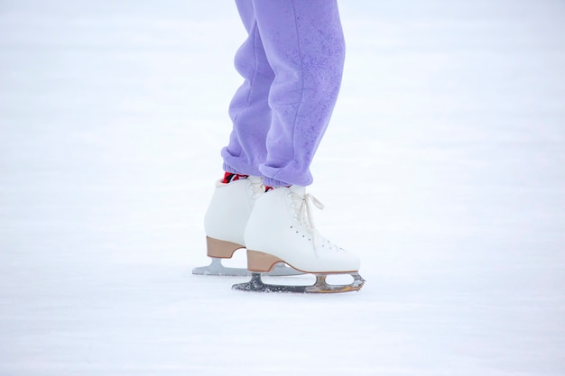 Beine einer Frau, die auf einer Eisbahn Schlittschuh läuft. Hobbys und Freizeit.