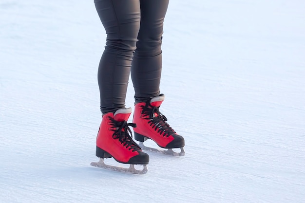 Beine eines Mädcheneislaufens auf einer Eisbahn. Hobbys und Freizeit. Wintersport