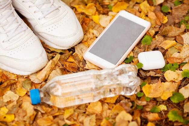 Beine eines Mädchens in den weißen Turnschuhen im Herbstlaub