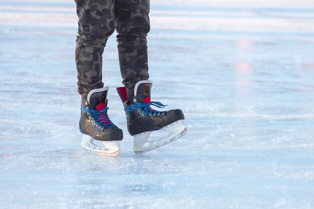 Foto beine eines mannes, der auf einer eisbahn schlittschuh läuft. hobbys und sport. urlaub und winteraktivitäten