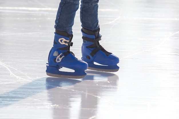 Beine eines Mannes, der auf einer Eisbahn Schlittschuh läuft Hobbys und Sport
