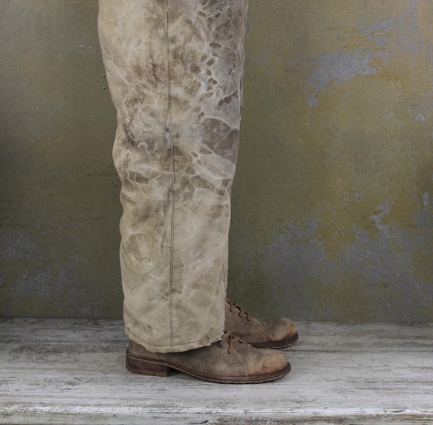 Foto beine eines mannes in alten hosen und alten schuhen