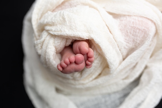 Beine eines Neugeborenen in einer weißen Decke. Neugeborenes. kleine Babyfüße