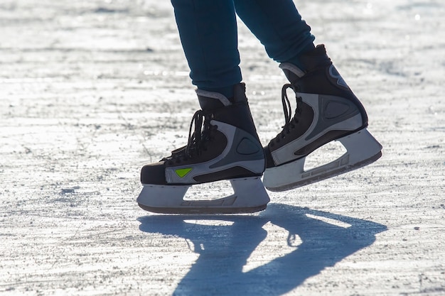 Beine eines Skaters beim Schlittschuhlaufen auf der Eisbahn. Wintersport. Hobbys und aktive Erholung im Sport.