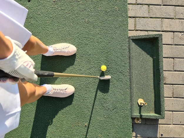 Foto beine frau golfspielerin mit golfschläger und ball