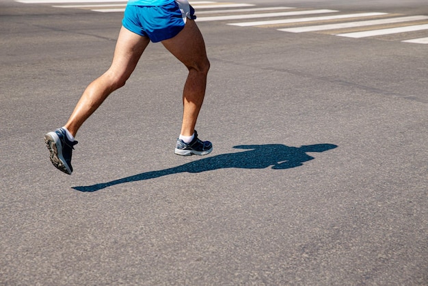 Beine männlicher Läufer läuft auf grauem Asphalt-Marathon