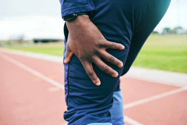 Beinschmerzen und schwarze Läufer Fitness und Rennen im Stadiontraining für Marathon oder Staffellauf im Freien Laufsportunfall und Entzündungsnotfall mit Muskelverspannungen und Mockup-Platz