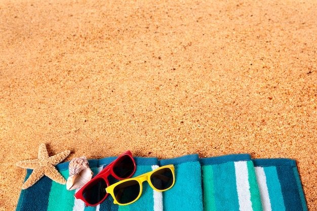 Beira do fundo da praia das férias de verão, óculos de sol, espaço da cópia da areia