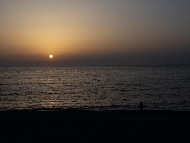 Beira-mar ao pôr do sol Fotografia escura do céu do pôr do sol Climas mais quentes