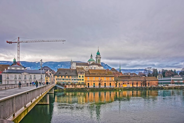 Beira-mar com a catedral de st ursus e o palais besenval. solothurn é a capital do cantão de solothurn, na suíça. está localizado nas margens do aare e no sopé das montanhas weissenstein jura