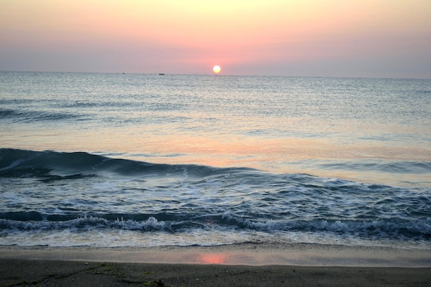 Beira-mar com ondas e pôr do sol