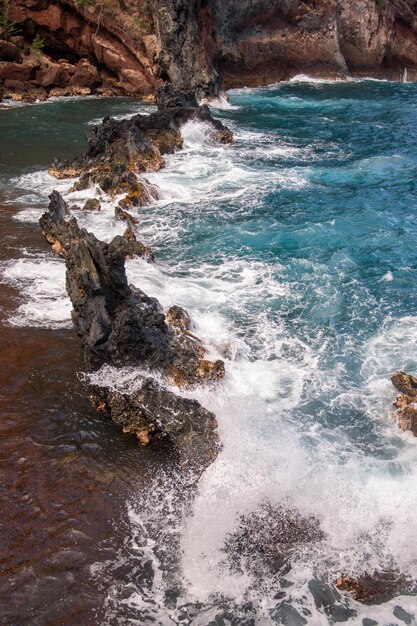 Beira-mar com paisagem marinha do oceano de pedras Ondas do mar sobre rochas na praia de pedra selvagem O mar tropical relaxa