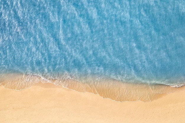 Beira-mar de areia com água do mar verde turquesa. Pequenas ondas na praia. Belo paraíso tropical
