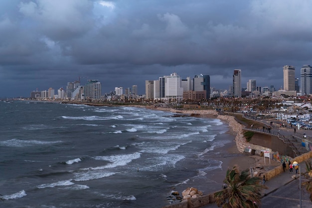 Beira-mar do horizonte noturno de Tel Aviv com arranha-céus de praias e vista à beira-mar de Jaffa