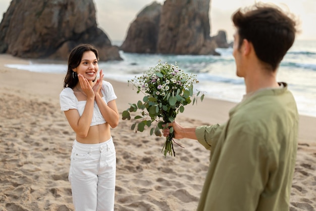 Beira-mar surpreende jovem encantando senhora com buquê de flores em encontro costeiro
