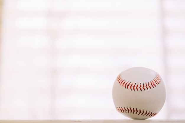 Béisbol en mesa con fondo de ventana