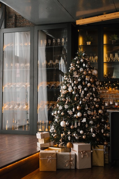 Bela árvore de Natal decorada com brinquedos de ouro e prata e caixas de presentes por dias em uma casa aconchegante