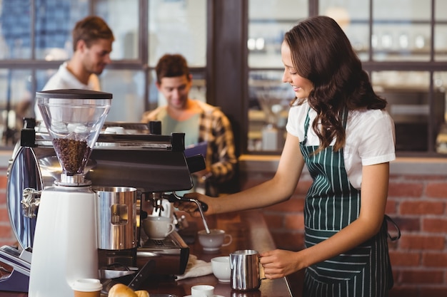 Bela barista fazendo uma xícara de café