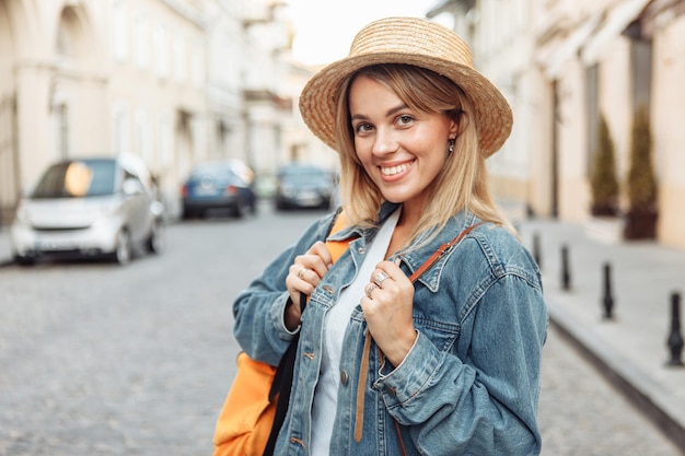 Bela bela turista milenar com mochila na jaqueta jeans descobre a cidade europeia em viagens de férias.