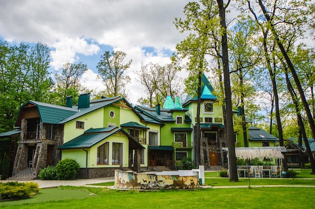 Bela casa de campo em tons de verde na floresta.