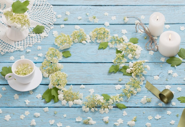 Bela composição com uma xícara de e flores brancas em um espaço de madeira azul