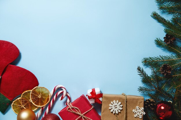 Bela composição de Natal sobre fundo azul. Caixas de presentes de Natal, meias, ramos de abeto, cones de coníferas, pau de caramelo, presente. Ano Novo. Vista superior, copie o espaço.