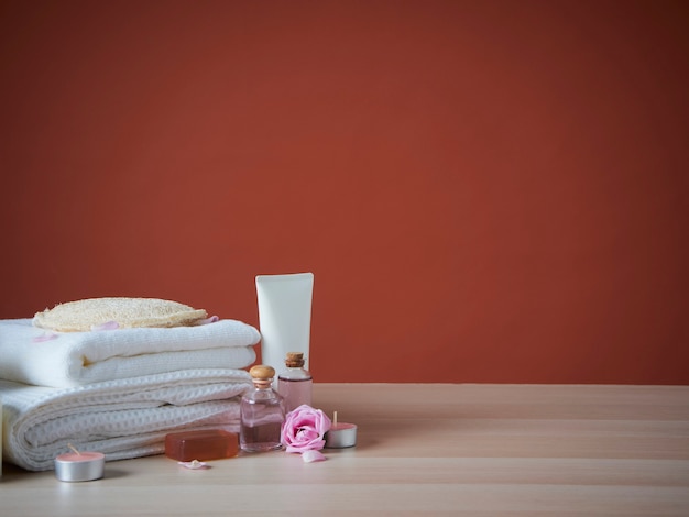 Bela composição de spa com óleo aromático, rosas cor de rosa na mesa de madeira