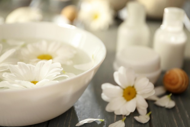 Bela composição de spa de flores em tigela com água na mesa