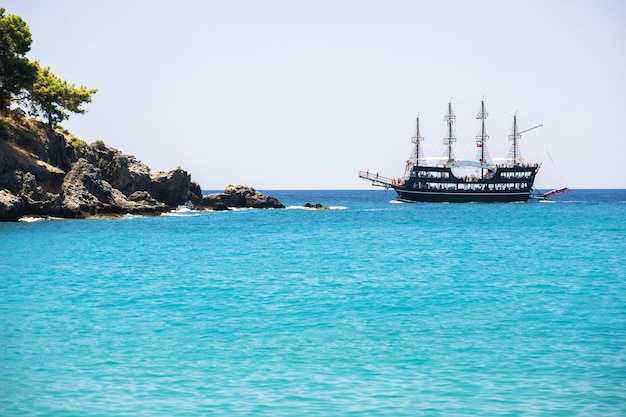 Bela costa do mar com água turquesa e navio turístico perto de Alanya Turquia Paisagem de verão Aventura de férias de verão conceito de férias ativas