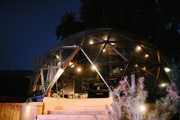 Bela esfera de café de vidro de verão à noite com iluminação