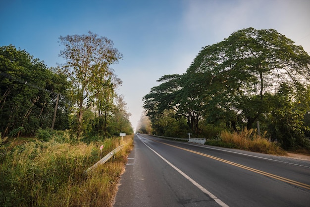 Bela estrada com névoa matinal na zona rural da cidade de nan na Tailândia.