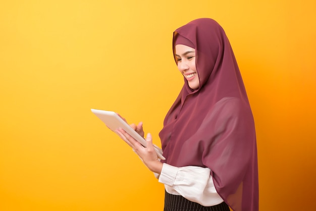 Bela estudante universitária com retrato de hijab em fundo amarelo