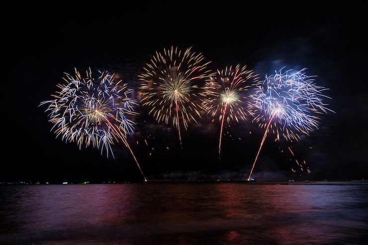 Foto bela exibição de fogos de artifício para celebração sobre o mar