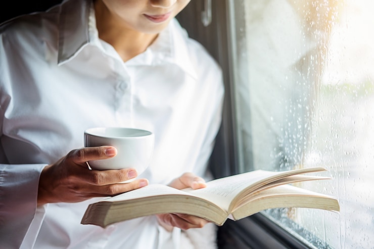 Foto bela fêmea sentada na cama e lendo um livro