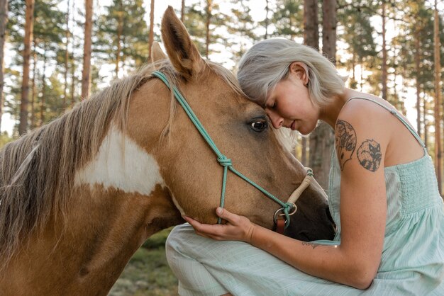 Bela foto de close de uma mulher pressionando a testa contra o cavalo