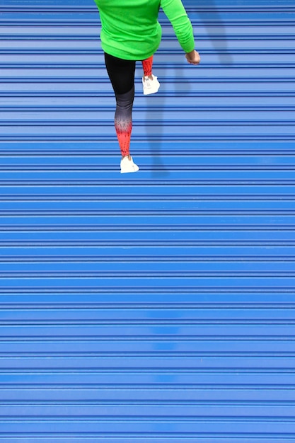Bela foto de um jovem macho correndo em um telhado azul