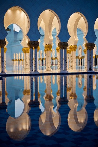 Bela galeria da famosa mesquita sheikh zayed white em abu dhabi, emirados árabes unidos à noite