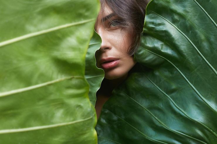 Foto bela garota de verão atrás de folhas de palmeira jovem mulher sexy em biquíni sob uma palmeira na selva retrato de beleza