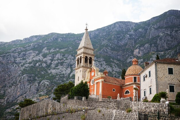 Bela igreja em um fundo de montanhas na cidade velha de Kotor, Montenegro.