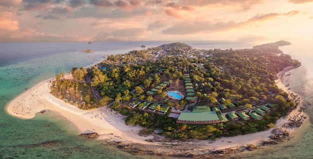 Bela ilha de koh lipe com barco de pesca tropical e resort na praia nas férias de verão ao pôr do sol