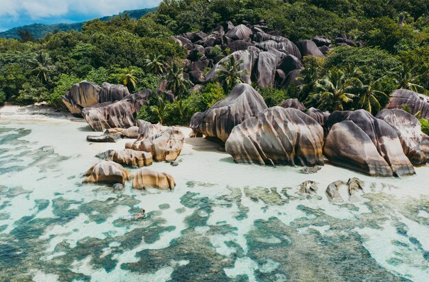 Bela ilha nas seychelles. La digue, praia de anse d'argent com vista aérea. Homem de caiaque com caiaque transparente de manhã