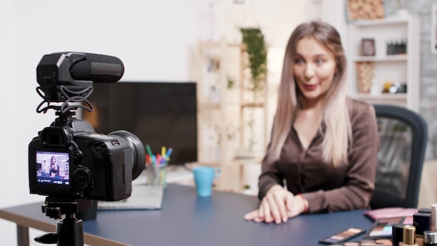 Bela influenciadora de beleza gravando um vídeo sobre maquiagem fashion. Criador de conteúdo criativo.