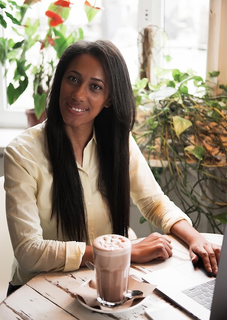 Bela jovem africana desfrutando de uma xícara de café