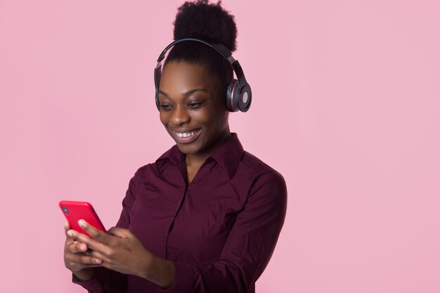 bela jovem africana em fones de ouvido com telefone